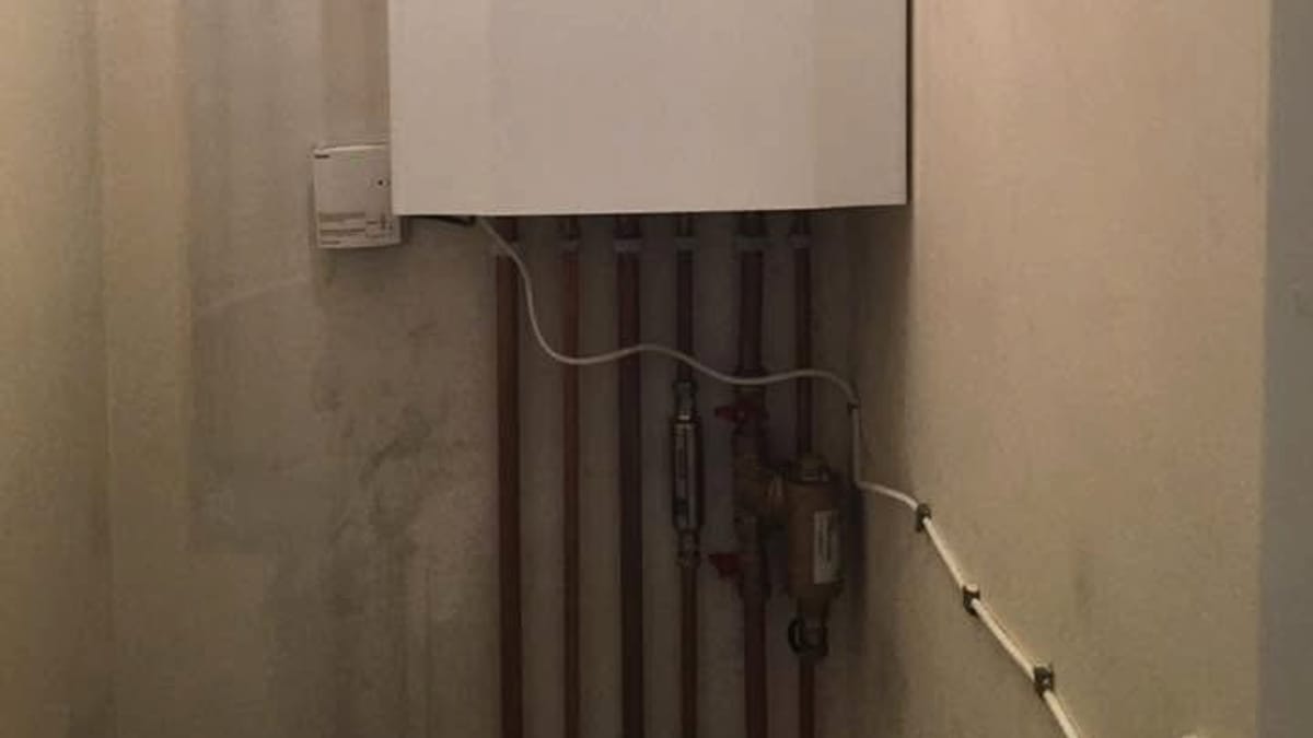 New copper pipework and an isolation valve below a freshly installed gas boiler